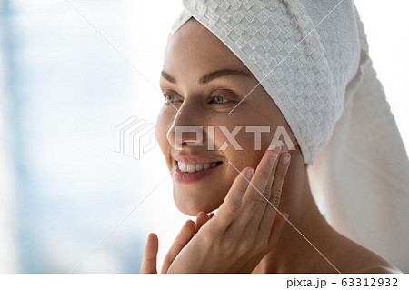 Beautiful happy young woman with towel on head looking away. 63312932