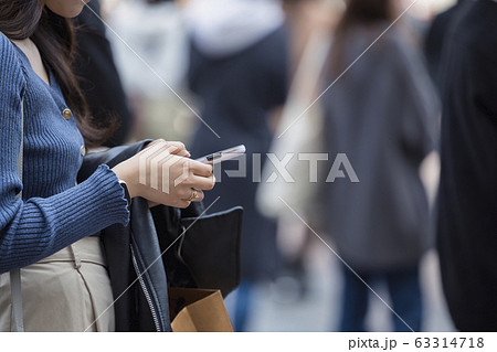 スマホを操作する若い女性の手元 63314718