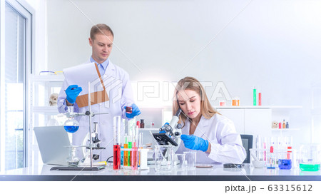 Two scientists researching for some confidential in chemical laboratory Two scientists researching for some confidential in chemical laboratory 63315612