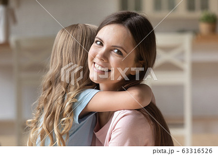 Portrait of smiling mom and little daughter hugging Portrait of smiling mom and little daughter hugging 63316526