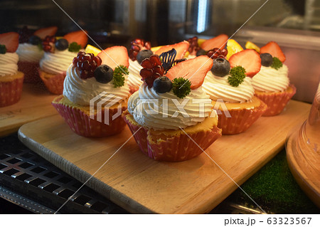 Strawberry and Raspberry cupcakes on wooden background Strawberry and Raspberry cupcakes on wooden background 63323567