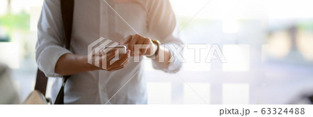 Cropped shot of male entrepreneur using smartphone 63324488