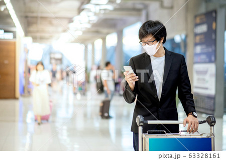 Asian businessman wearing mask in airport terminal Asian businessman wearing mask in airport terminal 63328161