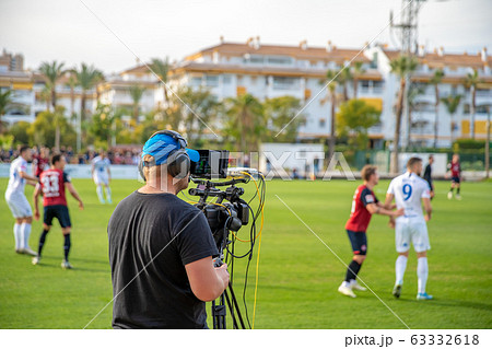 cameraman with camera shooting video on football game 63332618