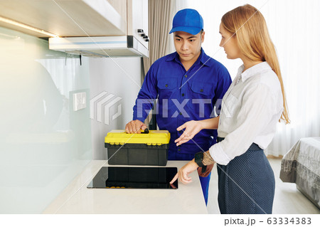 Woman talking to electrician Woman talking to electrician 63334383