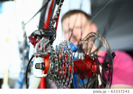 Repairman installing velocipede gear Repairman installing velocipede gear 63337245