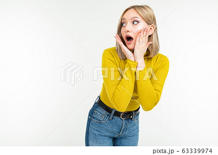 surprised girl in a lemon turtleneck and jeans posing on an isolated white background with copy 63339974