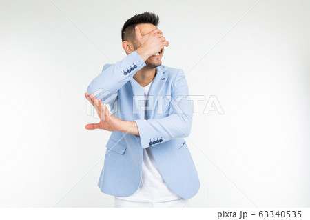 a man in a blue classic jacket closes his hand and asks to remove something on a white background a man in a blue classic jacket closes his hand and asks to remove something on a white background 63340535