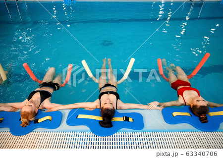 Female swimmers, aqua aerobics at the poolside Female swimmers, aqua aerobics at the poolside 63340706