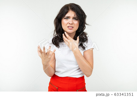 disgruntled girl in a white T-shirt is fed up on a white studio background 63341351