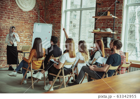Female muslim speaker giving presentation in hall at university workshop 63342955
