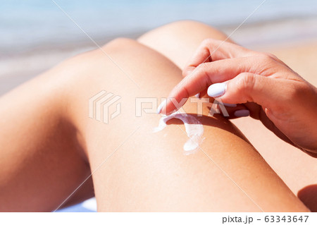 Closeup on female hand applying sunblock on her Closeup on female hand applying sunblock on her 63343647