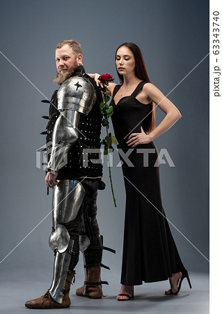 Beautiful girl in a black dress and knight in Beautiful girl in a black dress and knight in 63343740