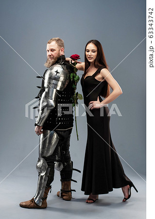 Beautiful girl in a black dress and knight in Beautiful girl in a black dress and knight in 63343742