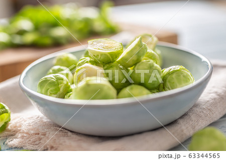 Fresh brusseles sprouts in bowl on kitchen table Fresh brusseles sprouts in bowl on kitchen table 63344565