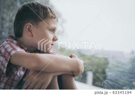 portrait one sad little boy sitting near a window portrait one sad little boy sitting near a window 63345194