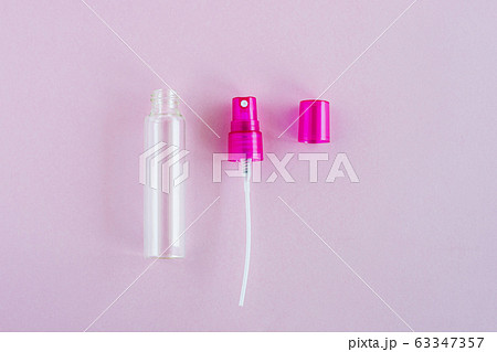 Transparent glass perfume and cosmetic spray bottle on pink background Transparent glass perfume and cosmetic spray bottle on pink background 63347357