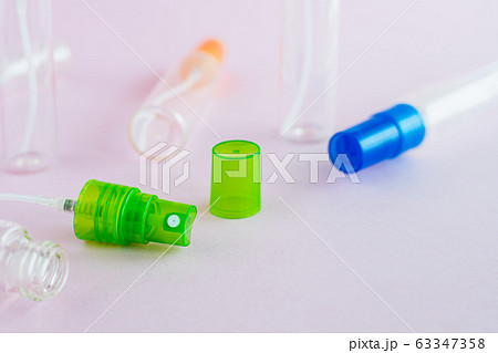 Transparent glass perfume and cosmetic spray bottle on pink background 63347358