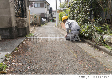 住宅とヘルメットのビジネスマン 現地調査 建て替えで接道を採寸 セットバック 建築基準法 住宅とヘルメットのビジネスマン 現地調査 建て替えで接道を採寸 セットバック 建築基準法 63347397