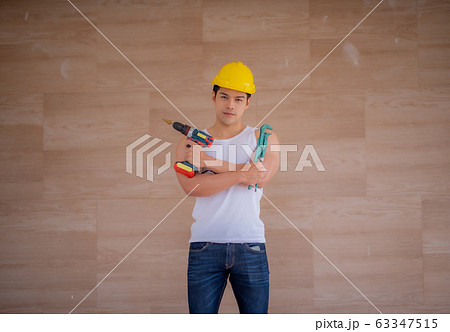 Strong worker, repair, piercing the wall, the man in the helmet, the concept of repair and renovation of buildings. 63347515
