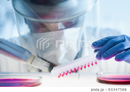 Scientist working in the corona virus vaccine development laboratory research with a highest degree of protection gear. Scientist working in the corona virus vaccine development laboratory research with a highest degree of protection gear. 63347566