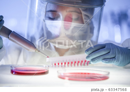 Female scientist working in the corona virus vaccine development laboratory research with a highest degree of protection gear. 63347568
