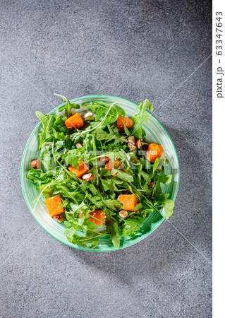 Delicious salad with arugula and baked pumpkin Delicious salad with arugula and baked pumpkin 63347643