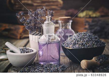 Bowl of lavender flowers, oil or water bottles. Bowl of lavender flowers, oil or water bottles. 63348926