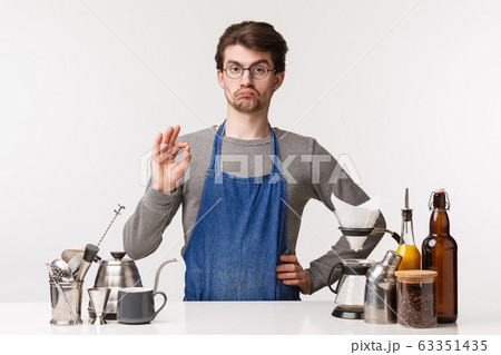 Barista, cafe worker and bartender concept. Very good, impressed and satisfied caucasian guy employee, running own business and working there, show okay sign, guarantee client will like coffee Barista, cafe worker and bartender concept. Very good, impressed and satisfied caucasian guy employee, running own business and working there, show okay sign, guarantee client will like coffee 63351435