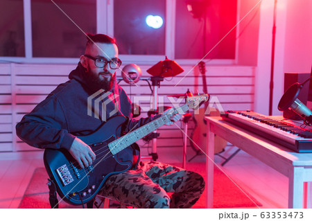 Musician and making music concept - Male sound producer working in recording studio. Musician and making music concept - Male sound producer working in recording studio. 63353473
