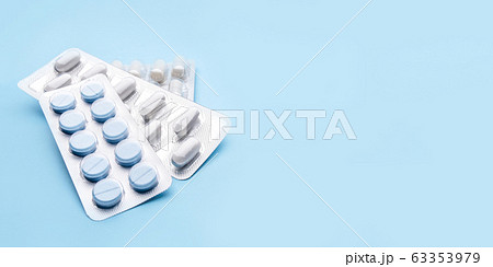 Pills in blister packs on blue background. 63353979