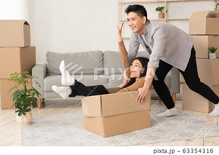 Happy man and woman having fun in their new flat Happy man and woman having fun in their new flat 63354316