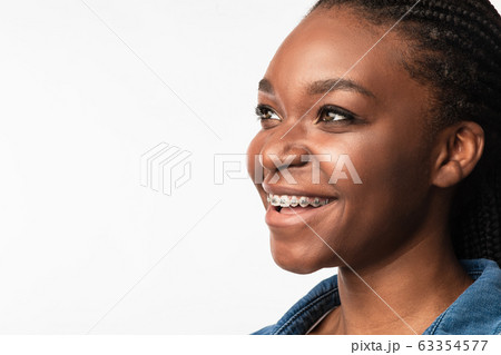 Girl With Dental Braces Smiling Looking Aside On White Background 63354577