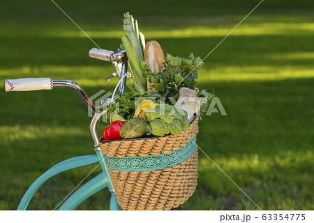 Close up of healthy fruits and vegetables in basket on bicycle 63354775