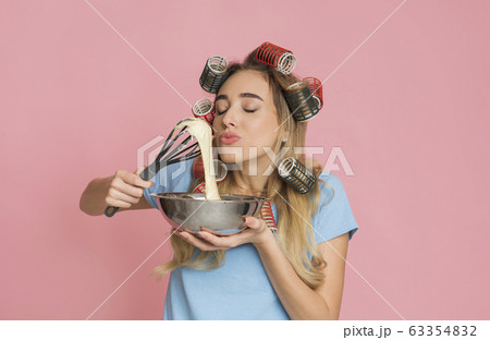 Housewife enjoys the smell food holding whisk and bowl in hands 63354832
