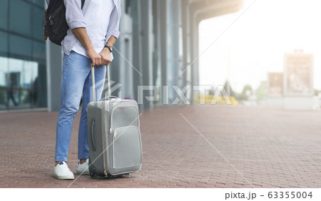 Waiting For Transfer. Unrecognizable Man Standing Near Airport Terminal With Luggage 63355004