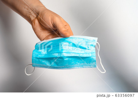 Protective face mask in hand. Surgical mask. Medical mask and corona virus protection. 63356097