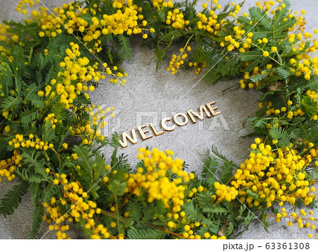 ミモザのリースと木製のアルファベットで作った「WELCOME」のメッセージ 63361308