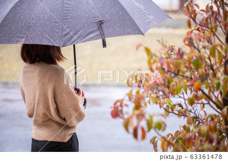 女性が雨の中傘を持っているの写真素材