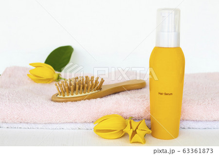 hair care serum for damaged hairs ,brush comb and terry cloth health care beauty head and hairs with yellow flower ylang ylang of lifestyle woman 63361873