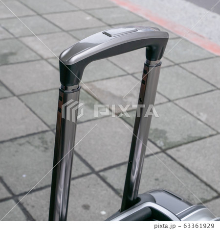 The close up of travel luggage handle on street at urban city. The close up of travel luggage handle on street at urban city. 63361929