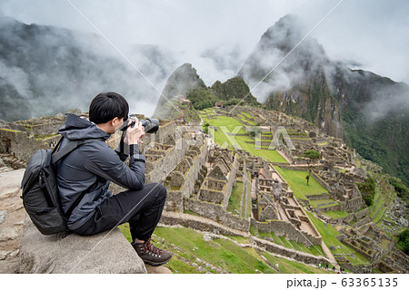 Asian man traveler taking photo at Machu Picchu 63365135