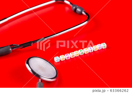 Pandemic and virus concept - Coronavirus text with syringe and phonendoscope on red background. Novel coronavirus Covid-19. Top view 63366262