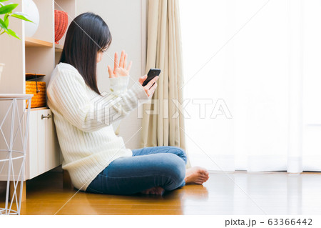 スマホを持ち手を振る女性 ビデオ通話 アプリ 自撮り セルフィー 配信 コピースペース スマホを持ち手を振る女性 ビデオ通話 アプリ 自撮り セルフィー 配信 コピースペース 63366442