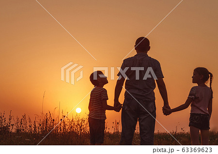 Father and children standing in the park at the 63369623