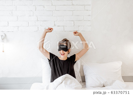 Woman waking up in bed Woman waking up in bed 63370751