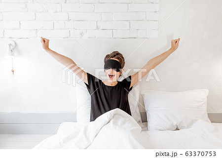 Woman waking up in bed 63370753