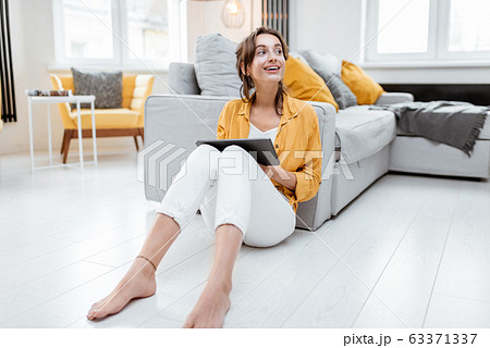Woman working on digital tablet at home Woman working on digital tablet at home 63371337