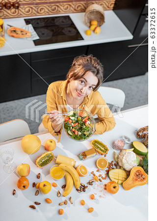 Young woman with healthy fresh food on the kitchen 63372615