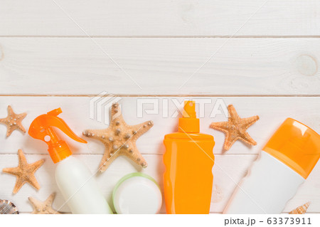 Sunscreen bottles with seashells on white wooden 63373911